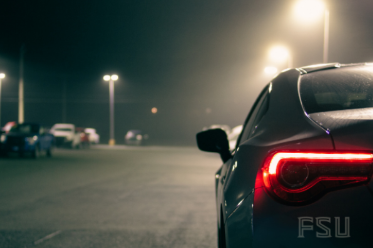 A car parking on campus at night